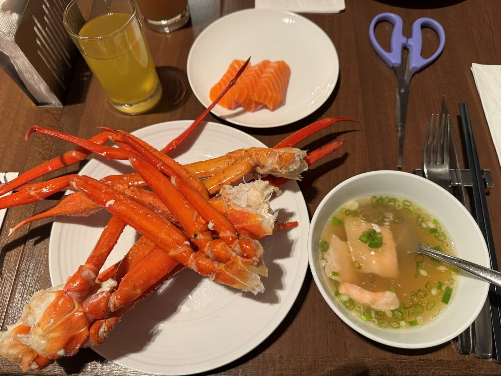 一盤蟹腳、一小盤鮭魚生魚片和一碗清湯