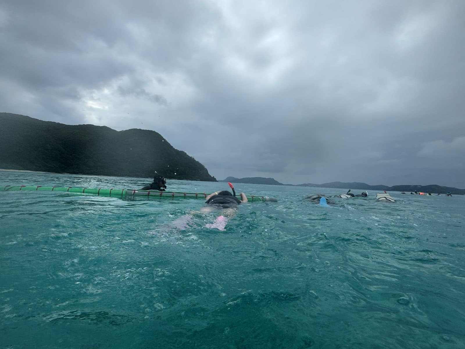 浮潛的人沿著浮力繩排成一列
