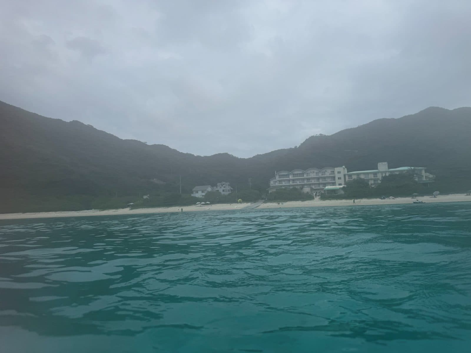 下午浮潛的渡嘉志久海灘,岸邊有白色建築